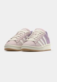 Lilac and purple suede sneakers with white three-stripe design, cream laces, and a gum sole. Features a round logo on the tongue.