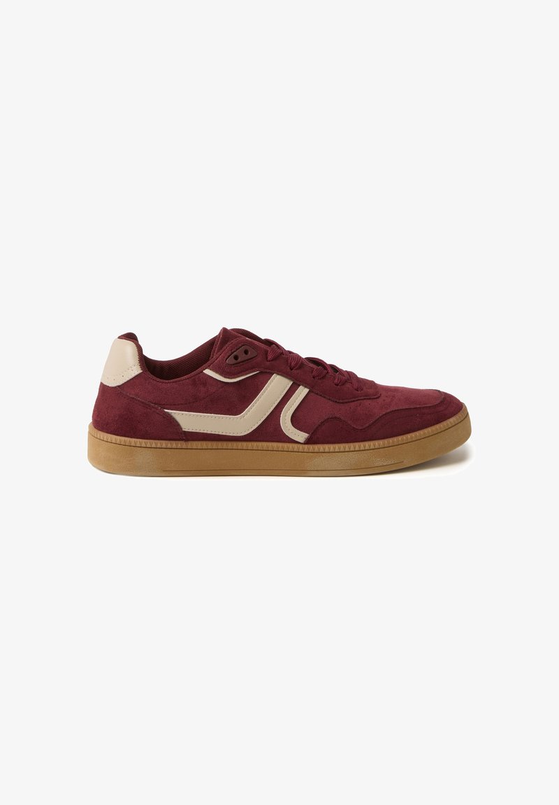 Zapatillas de ante burdeos con acentos en crema, punta redondeada, suela texturizada y diseño de cordones. Cuenta con una suela de goma de perfil bajo.