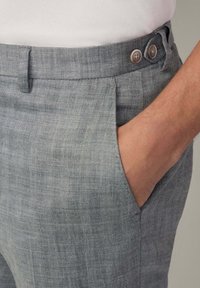 Grijs houndstooth broek van een gestructureerde stof, met een vlakke voorkant, zijzak en twee metalen knopen op de tailleband.