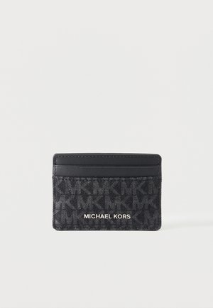 Porte-cartes noir Michael Kors avec motif de logo embossé et deux emplacements pour cartes sur fond blanc uni.