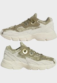 Chunky sneakers i olivgrön och krämfärgad, med vadderat läder och syntetiska material, distinkta öglor och texturerade gummisulor.