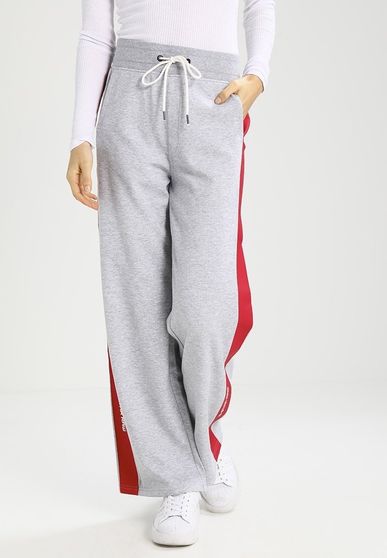 Grå sweatshirtbyxor med röda sidost stripes, med dra åt midja, vida ben och fickor. Tillverkade av mjukt, stretchigt material.