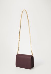 Bolsa de ombro de couro borgonha com uma alça em corrente dourada, forma retangular e textura suave; possui um logotipo da marca discreto.