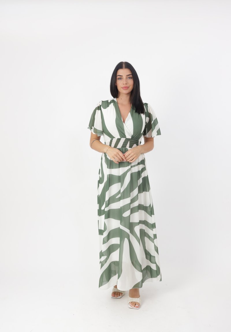 Robe maxi verte et blanche, présentant de larges rayures abstraites. Décolleté en V, manches courtes flottantes, et design taille froncée.