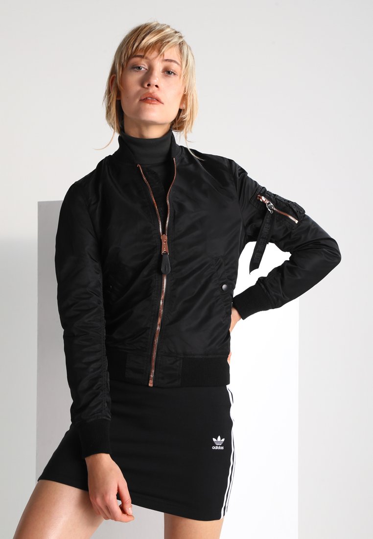 Veste bombardier noire en nylon brillant, avec fermeture à glissière, poignets à côtes et une poche zippée supplémentaire sur la manche.