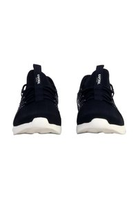 Chaussures de sport en maille noires avec semelles blanches, présentant une tige texturée, un design à lacets et des onglets de talon avec logo.