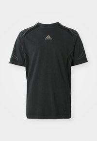 Black Adidas T-shirt, short sleeves, with a round neck. Features subtle side accents and a small logo on the chest in silver. Cotton material.