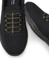 Scarpe sportive nere realizzate in tessuto a maglia con un design testurizzato; chiusura senza lacci con accenti gialli; suola in gomma nera morbida.