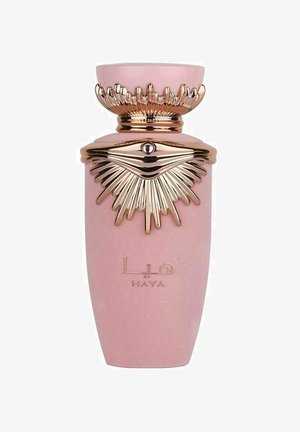 Vaaleanpunainen parfyymipullo, jossa on kapeneva muoto, kulta-akcentteja ja teksturoitu korkki, joka muistuttaa säteitä. Pullossa on brändin nimi 'HAYA' kohokuvioituna kultaisella.