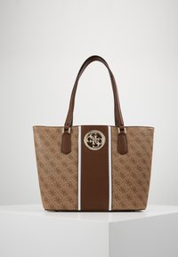 Brązowa torba na ramię z wzorzystym beżowym materiałem, dwoma brązowymi skórzanymi uchwytami, centralnym brązowym paskiem oraz srebrnym okrągłym logo z przodu.