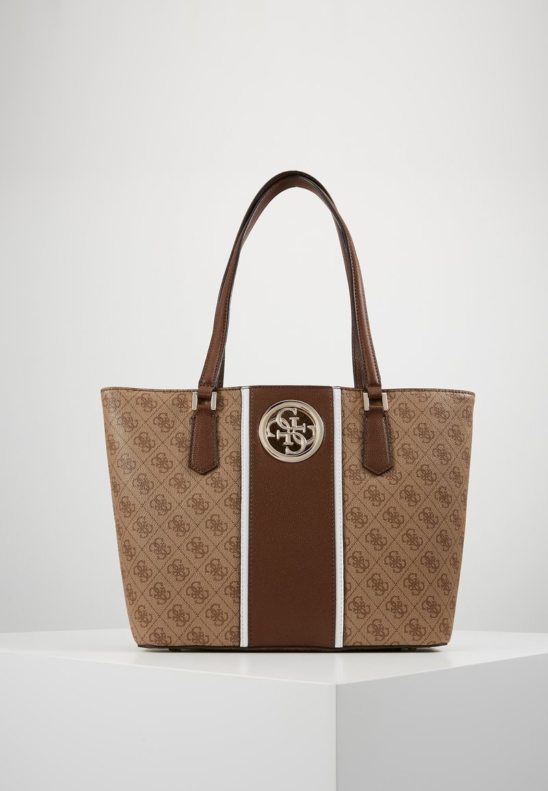 Brązowa torba na ramię z wzorzystym beżowym materiałem, dwoma brązowymi skórzanymi uchwytami, centralnym brązowym paskiem oraz srebrnym okrągłym logo z przodu.