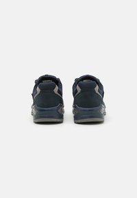 Marineblauwe sportschoenen met een textiel bovenwerk, grijze accenten, een gevoerde kraag en een doorschijnende rubberen zool.