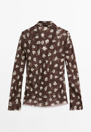 Brown floral blouse with long sleeves, lightweight fabric, subtle texture, notched collar, and delicate white flower pattern throughout.