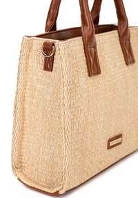 Borsa a tracolla intrecciata in paglia con manici in similpelle marrone e accento metallico circolare vicino alla parte superiore; forma rettangolare e superficie testurizzata.