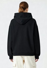 Felpa nera oversized con tasca a canguro, polsini e orlo ribattuti. Il tessuto sembra morbido con una trama liscia. Cappuccio attaccato.