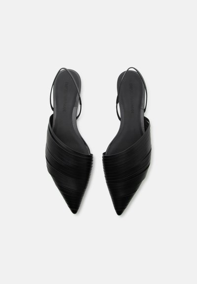 Μαύρες μπαλαρίνες slingback με μυτερή μύτη, με στρωτά δερμάτινα λουράκια και λεπτά ελαστικά λουράκια στη φτέρνα, φαίνονται από πάνω σε λευκό φόντο.