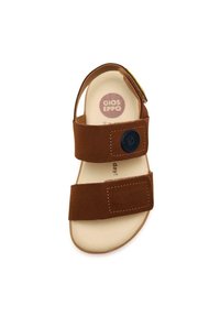 Sandal in suede marrone con due cinturini regolabili in Velcro, dettaglio rotondo con logo e suole beige. Texture liscia e design aperto per traspirabilità.