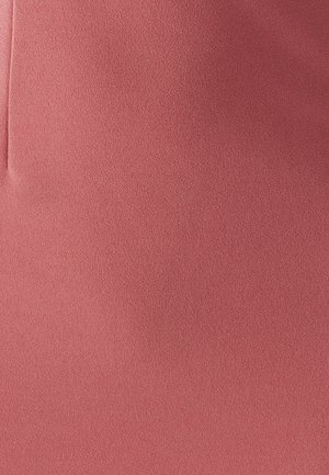 Tissu rose texturé et doux, avec une finition lisse et un léger extensibilité. Comprend des détails de couture pour façonner sans poches.