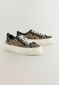 Tenisice s uzorkom leopard, s gornjim dijelom od teksturiranog platna, bijelim gumeni potplat i kontrastnim crnim vezicama. Čvrst dizajn s ravnim profilom.