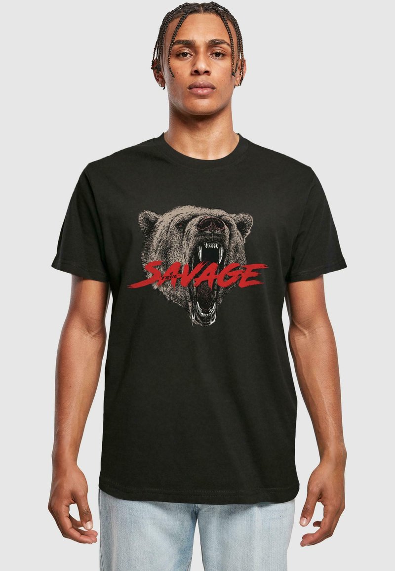 Svart bomullst-skjorte med et detaljert, knurrende bjørne-graphic med ordet "SAVAGE" i fet rød under. Standard rund hals-design.