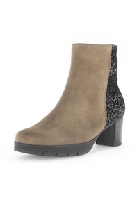 Bottine en suède marron clair avec un panneau à motif de lacets noirs et un talon bloc. Elle présente une pointe arrondie et une semelle texturée pour une meilleure adhérence.