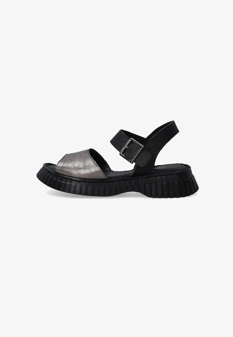 Černé sandály s metalickou stříbrnou barvou, které mají široký přední popruh, nastavitelnou sponu a texturovanou platformu s vroubkovaným vzorem.