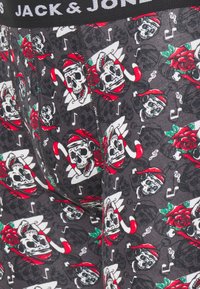 Schwarze Boxer-Briefs mit einem Totenkopfdesign, verziert mit roten Rosen, Noten und einem weihnachtlich gestalteten Weihnachtsmann-Hut-Muster. Stretchstoff mit einem markierten Bund.