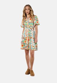 Robe colorée à manches courtes avec des motifs floraux et géométriques. Elle présente une taille cintrée et une jupe évasée. Le matériau semble léger et respirant.