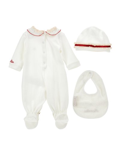 Body bianco per neonato con colletto a onde e accenti rossi, cappellino coordinato con volant e fascia rossa, e un bavaglino bianco con una texture a spirale.