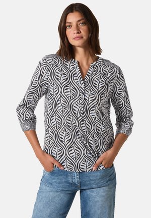 Blouse à motif noir et blanc avec un design de feuilles, dotée d'un décolleté en V et de manches trois-quarts, agrémentée de détails en boutons.
