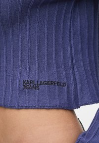 Modrý žebrovaný top s logem Karl Lagerfeld Jeans v černé výšivce na spodním lemu, který předvádí strukturovaný vzor a přiléhavý střih.