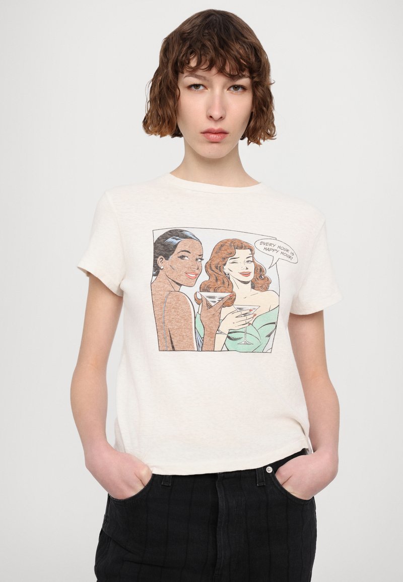 T-shirt in cotone color crema con una grafica di due donne che tengono dei cocktail. Il design include colori pastello e testo di dialogo.