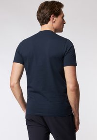 Navy blauwe getailleerde t-shirt van katoen met korte mouwen, een ronde hals en een gladde textuur. Eenvoudig ontwerp zonder zichtbare patronen of accenten.