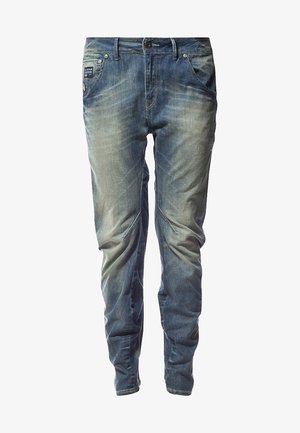 Jeans de mezclilla azul claro con un acabado desgastado, cinco bolsillos y cierre de botón. Presenta detalles de costura sutiles y un diseño de corte ajustado.