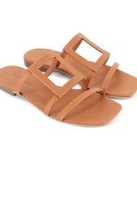Sandalias de cuero color marrón con suela plana, punta cuadrada y dos correas anchas con acentos rectangulares cortados. Textura suave con un detalle mínimo.