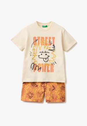 Kremowy t-shirt z krótkim rękawem z napisem "Street Power" i grafiką uśmiechniętego słońca, zestawiony z pomarańczowymi szortami z pasującym wzorem słońca.
