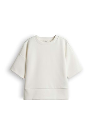 Sweat-shirt blanc à manches courtes avec col rond, coupe décontractée, et détail de couture au-dessus de l'ourlet, présenté sur un fond blanc uni.