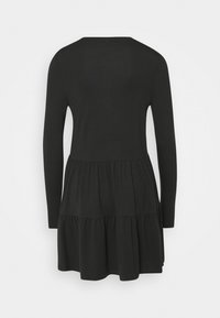 Svart långärmad klänning med rund halsringning, med en lager-på-lager kjoldesign och ett mjukt, texturerat tyg. Bakifrån visar den enkelhet.