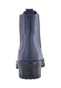 Botines de color azul marino con un acabado de cuero suave, que presentan un tacón ancho negro y costuras blancas a lo largo de las costuras.