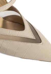Beige Lederpumps mit spitzem Zehenbereich, die ein geprägtes Krokodilmuster, ein Mesh-Ausschnitt und einen schmalen Riemen über dem Knöchel aufweisen. Glatte Textur.