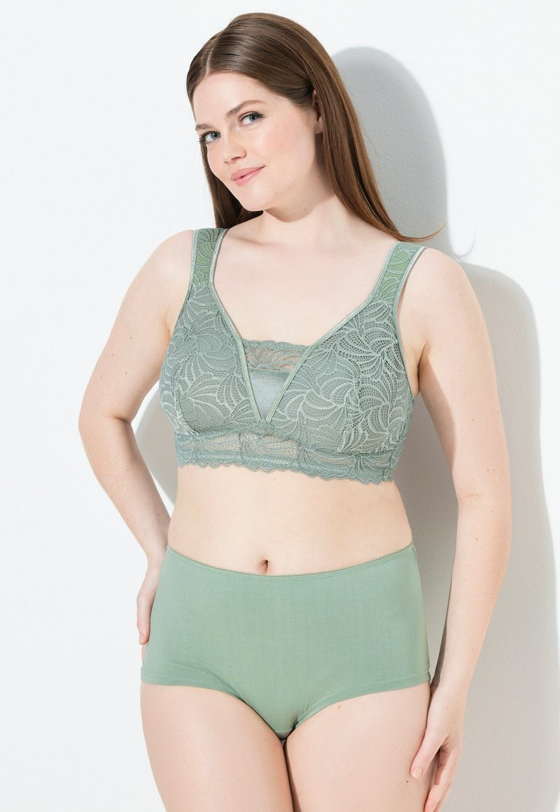 Bralette verde in pizzo con scollo a V profondo e spalline più larghe, abbinato a slip a vita alta coordinati. Texture morbida e liscia, motivo intricato.
