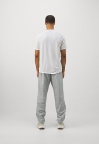 Under Armour RIVAL WOVEN - Broek - mod gray/white