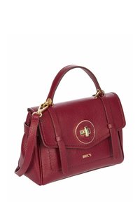 Sac à main en cuir bordeaux avec une texture grainée, quincaillerie dorée, bandoulière détachable et un fermoir circulaire avec la marque sur le côté.