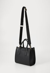 Black leather handbag with structured design, dual short handles, and an adjustable black strap featuring logo detail. Gold-tone hardware accents.