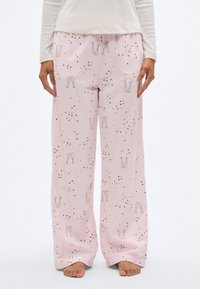 Ροζ παντελόνια πιτζάμας με χαλαρή εφαρμογή, σχέδιο με ποτήρια σαμπάνιας και αστέρια, με μαύρες και πορτοκαλί λεπτομέρειες. Απαλό ύφασμα με ομαλή υφή.