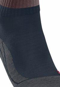 Skarpetki na kostkę w granatowo-szarym kolorze z prążkowaną teksturą i kontrastowym różowym logo. Charakteryzują się eleganckimi, bezszwowymi krawędziami oraz lekką konstrukcją.