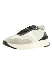 La sneaker présente un dessus en cuir lisse gris et blanc avec des lacets noirs, une semelle rembourrée et un design de bout arrondi.