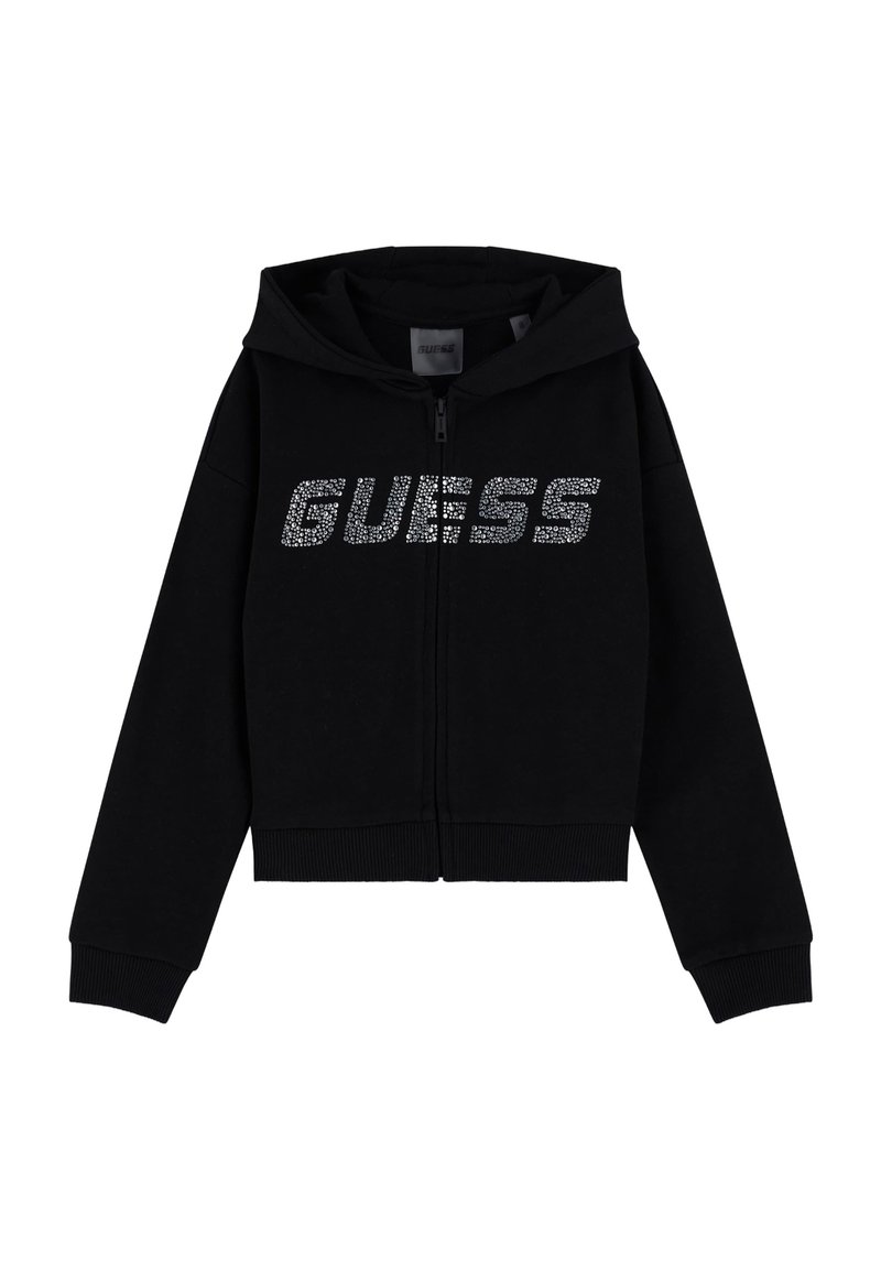 Haut à zip noir en tissu doux, avec capuche, poignets côtelés et un logo argenté scintillant "GUESS" sur la poitrine.