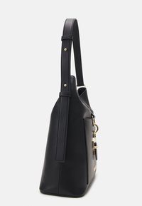 Svart läderhandväska med en strukturerad form, platt sida, lång rem och detaljer i guldfärgade metalldelar. Slät textur med minimalistisk design.