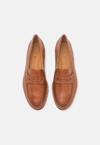 Brown leather loafers featuring a smooth texture, decorative stitching, and a flexible sole. The interior is labeled "SUPER SOFT."